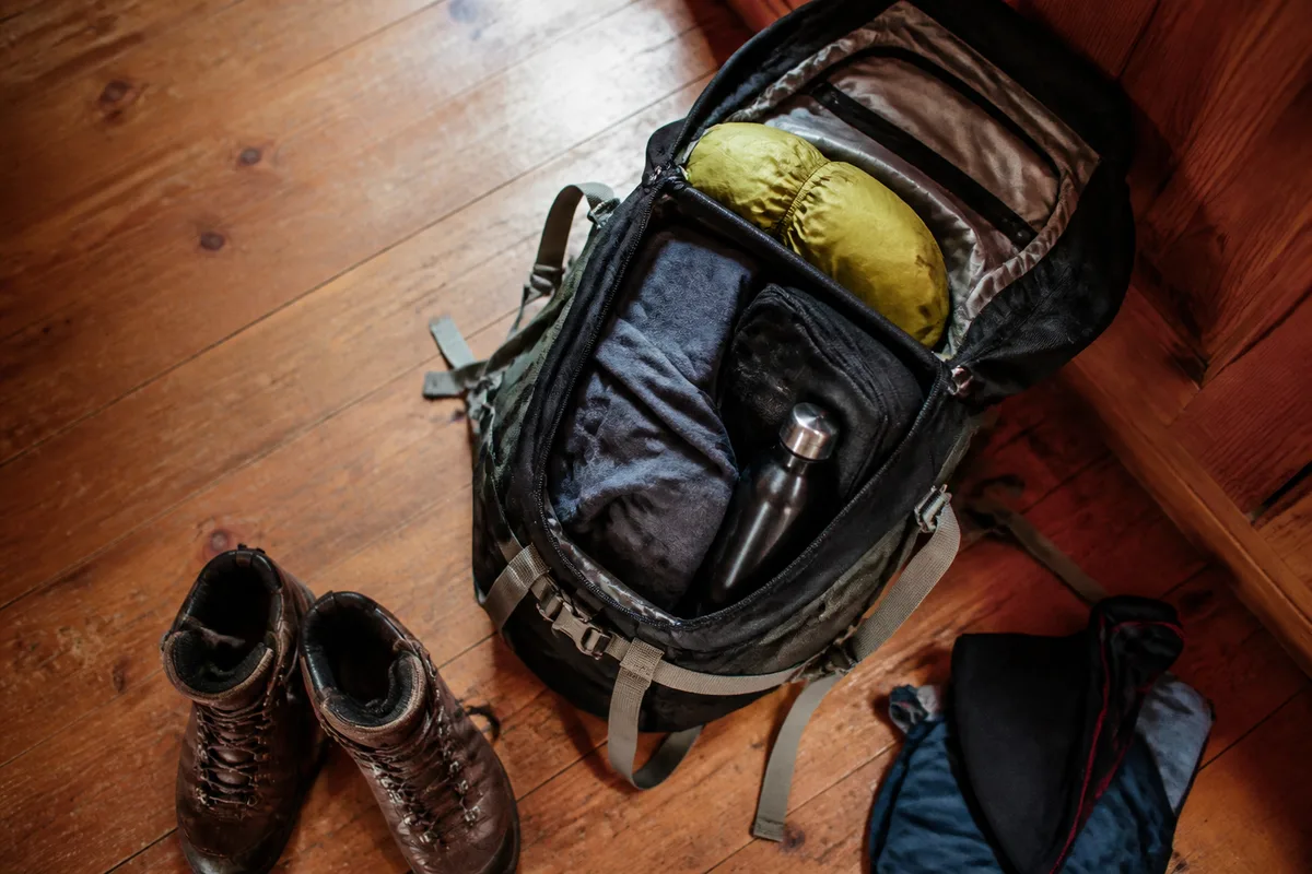Organisation d’un sac de randonnée ouvert avec vêtements et matériel répartis par niveau d’accès